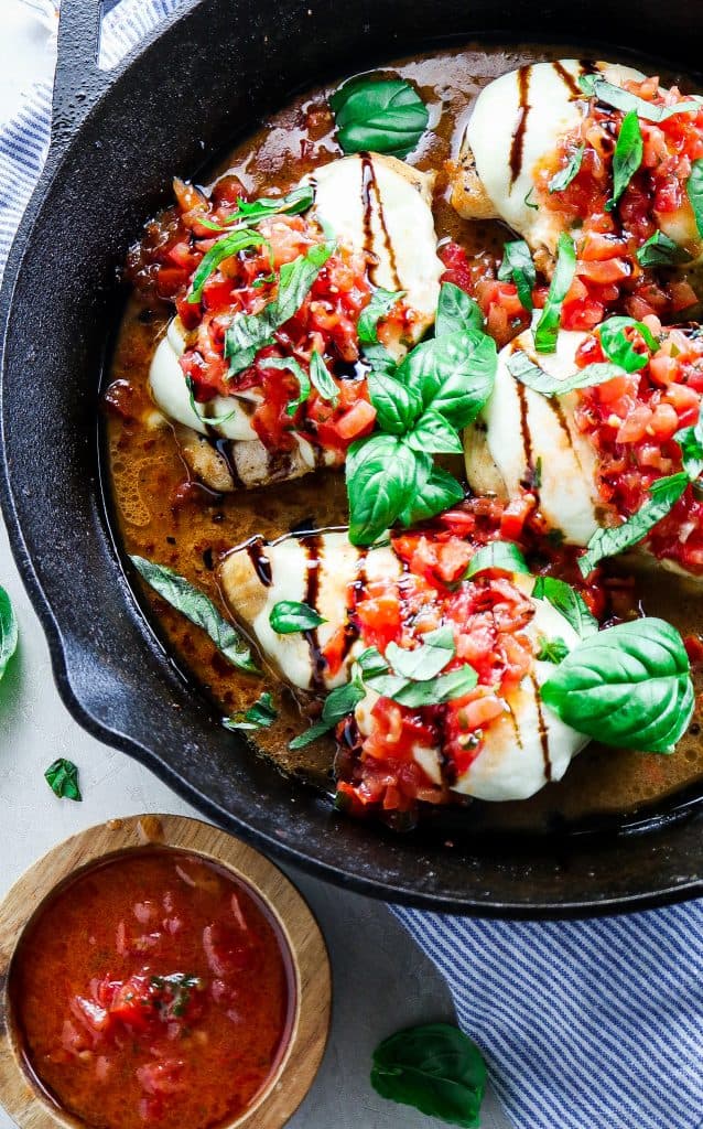 5 Ingredient Trader Joe's Bruschetta Chicken made in a cast iron skillet  with melted mozzarella cheese, fresh basil, and ready in 20 minutes or less.  