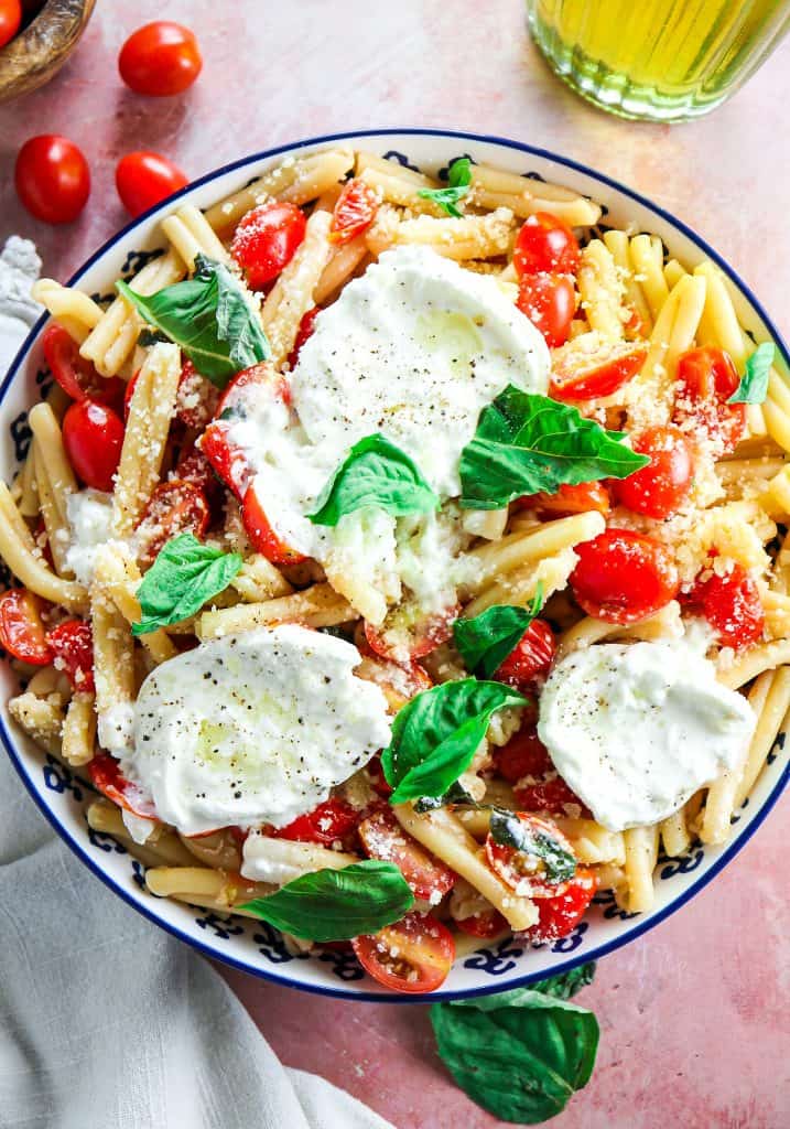 big bowl of tomato and basil pasta with fresh burrata and basil 