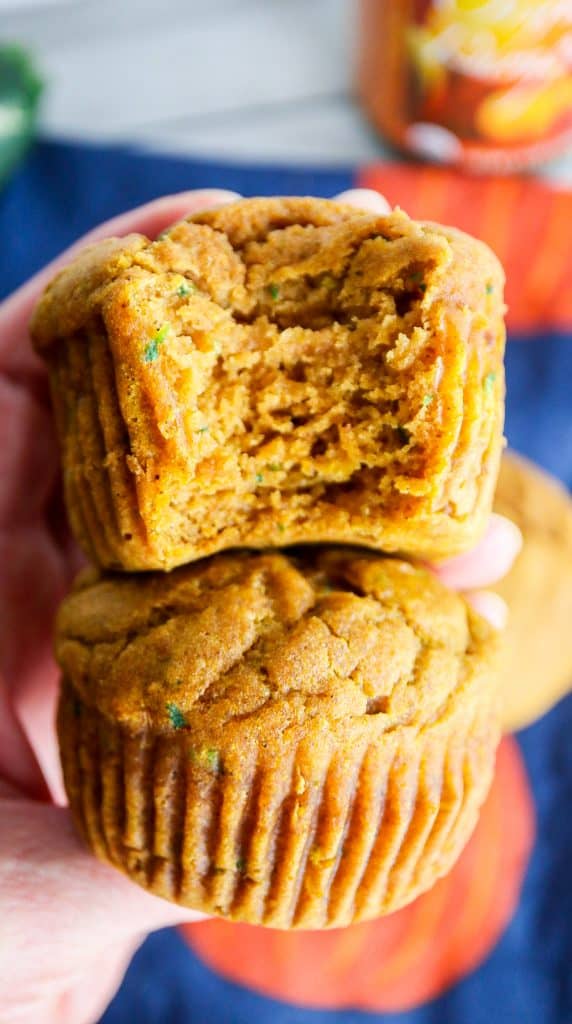 two zucchini pumpkin muffins stacked on top of each other