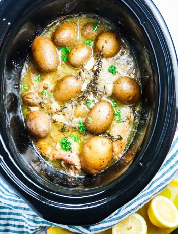 chicken and potatoes in a crockpot with fresh thyme and lemon juice
