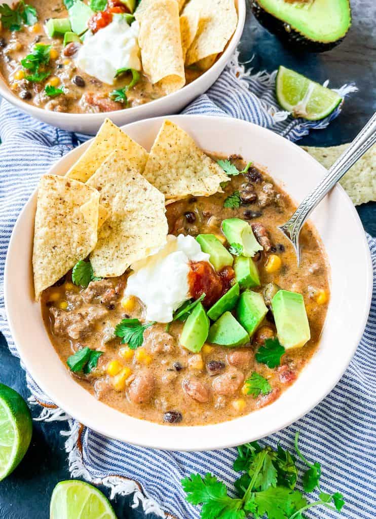 low carb gluten free taco soup in bowls on a blue striped napkin with cilantro and lime