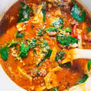 dutch oven with lasagna soup made with ground beef, tomato sauce, spinach, and spices