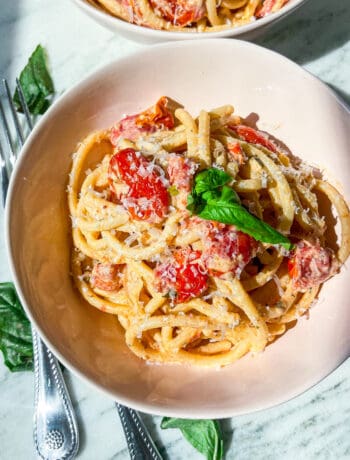 creamy Boursin tomato pasta with fresh basil and parmesan in pink bowls