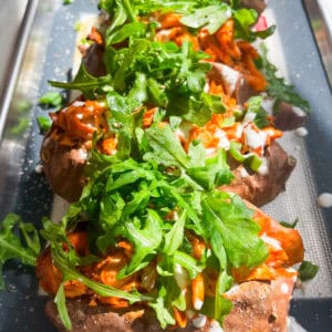 buffalo chicken stuffed sweet potatoes with arugula, ranch, and green onions