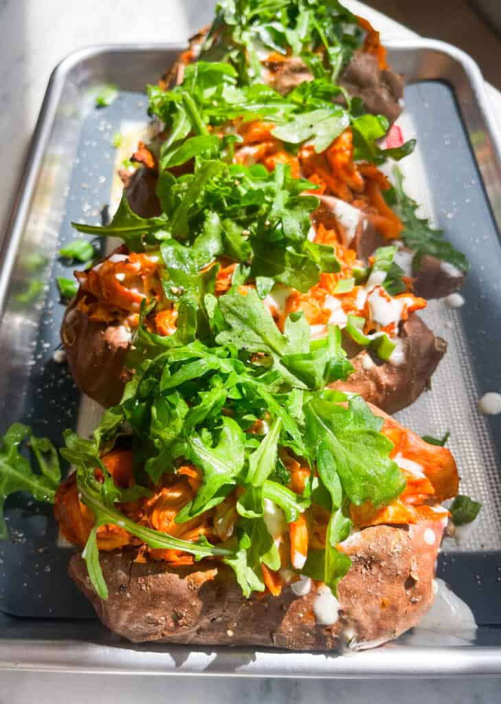 buffalo chicken stuffed sweet potatoes with arugula, ranch, and green onions 