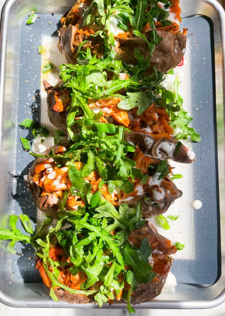 5 ingredient sheet pan buffalo chicken sweet potatoes with ranch, green onions, and arugula 