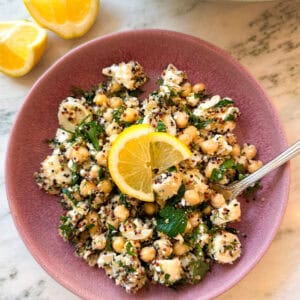 lemon dill quinoa chickpea feta salad with hearts of palm in a pink bowl