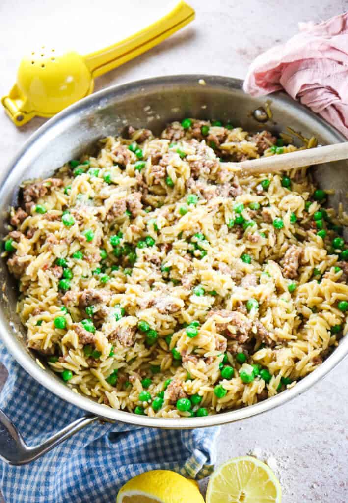 orzo skillet with peas and parmesan topped with lemon and parmesan 