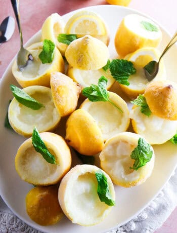 Lemon sorbetto cups served in hollowed out lemons garnished with mint leaves