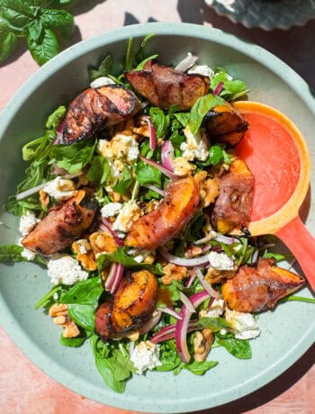 grilled peaches wrapped in proscuitto served on a bed of arugula with red onion, goat cheese, walnuts, and a honey balsamic vinaigrette