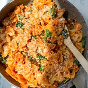 the easiest fall pasta using all trader joes ingredients-farfalle pasta, pancetta, shallots, autumnal harvest pasta sauce, and kale.