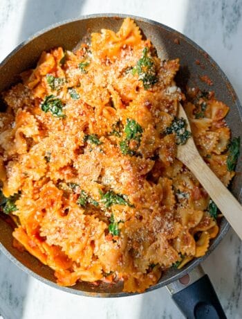 the easiest fall pasta using all trader joes ingredients-farfalle pasta, pancetta, shallots, autumnal harvest pasta sauce, and kale.